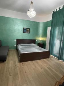 - une chambre avec un lit, des murs verts et un lustre dans l'établissement Camera Smeraldo, à Senigallia