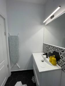 een witte badkamer met een wastafel en een douche bij Victoriei Light&Comfort in Boekarest +5 foto's
