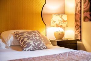 un letto con cuscino e lampada su un comodino di Harvest 13 Lodge, Yellowtop Country Park a York Altre 3 foto