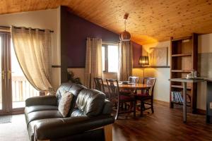 un soggiorno con un divano in pelle e un tavolo di Harvest 13 Lodge, Yellowtop Country Park a York