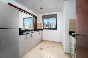 a kitchen with a sink and a window with a city skyline at Moderne 1BR with a lovely marina view in Dubai +30 photos