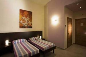 a hotel room with two beds and a painting on the wall at Santa Marta in Matera