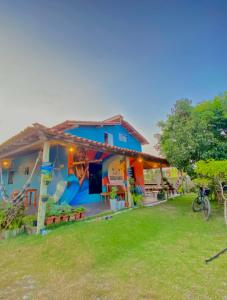 Hostel Caraivando في كرايفا: منزل أزرق مع دراجة متوقفة أمامه