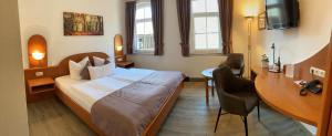 a hotel room with a bed and a desk at Hotel Zur Fernmühle in Ziegenrück