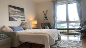 una camera da letto con un letto, una sedia e finestre di Simmerdeis am Hafen a Husum