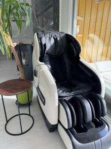 a black and white chair next to a table at Just Like Home Bed & Spa Porsgrunn in Porsgrunn