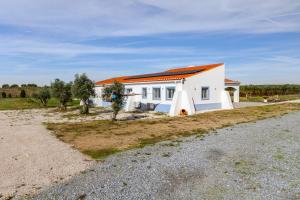 ein weißes Haus mit orangefarbenem Dach auf einer Straße in der Unterkunft Casa Maria D'Almeida in Reguengos de Monsaraz