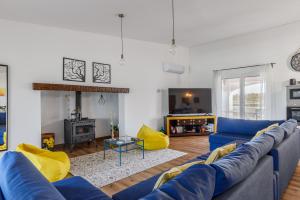 ein Wohnzimmer mit einer blauen Couch und einem Kamin in der Unterkunft Casa Maria D'Almeida in Reguengos de Monsaraz