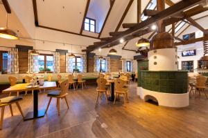 a restaurant with tables and chairs and a fireplace at Genuss- und Wellnesshotel Puchas Kukmirn in Kukmirn