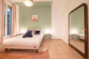 sypialnia z łóżkiem i dużym lustrem w obiekcie Spacious 2-bedroom in the centre of Menton w Mentonie