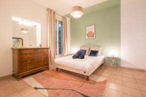 sypialnia z łóżkiem, komodą i lustrem w obiekcie Spacious 2-bedroom in the centre of Menton w Mentonie