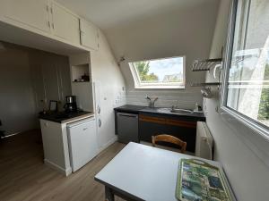a small kitchen with a sink and a table at Rayon De Soleil in Courseulles-sur-Mer +5 photos
