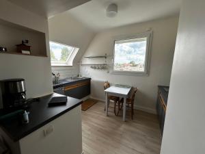 a small kitchen with a table and a window at Rayon De Soleil in Courseulles-sur-Mer