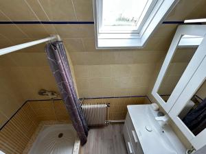 a bathroom with a shower and a sink and a window at Rayon De Soleil in Courseulles-sur-Mer