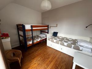 a bedroom with two bunk beds and a chair at Rayon De Soleil in Courseulles-sur-Mer