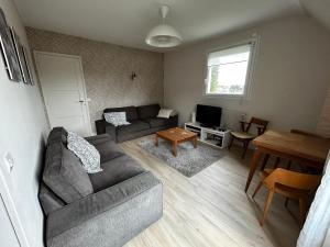 a living room with a couch and a table at Rayon De Soleil in Courseulles-sur-Mer