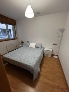 a bedroom with a bed and a lamp at Malpica Beach in Malpica +19 photos