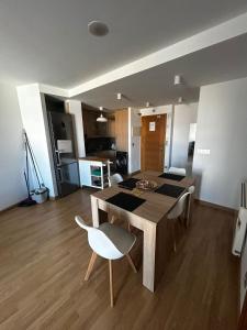 a living room with a wooden table and a white chair at Malpica Beach in Malpica