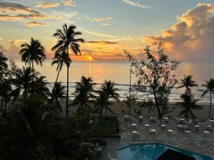 puesta de sol sobre una playa con palmeras y piscina en Praia de Piedade flat frente para o mar, completo Edf Golden Beach, en Recife