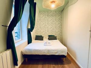 - une petite chambre avec un lit et une fenêtre dans l'établissement La Bonbonnière verte, à Caen