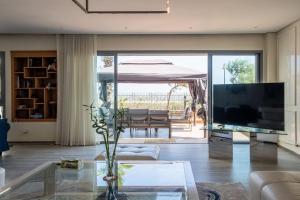 a living room with a large television and a table at Marina Sea View Appartements in Casablanca