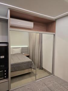 a bedroom with a bed and a mirror at Apto studio, coracao de maringa in Maringá