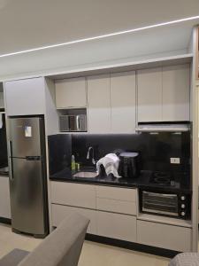a kitchen with white cabinets and a stainless steel refrigerator at Apto studio, coracao de maringa in Maringá +18 photos