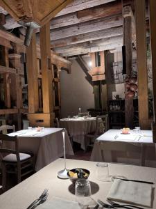 a dining room with two tables with white tablecloths at Hacienda De Leon in Isola della Scala