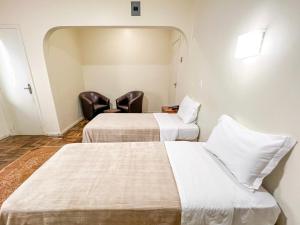 En eller flere senger på et rom på Hotel Ibiá