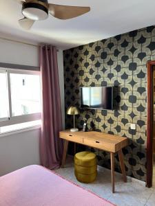 a bedroom with a desk and a tv on a wall at CORNELIAS HOME TC3 Atico in Los Cristianos