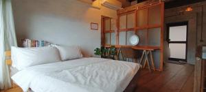 a bedroom with a white bed and a mirror at 雜院-晴海 新北市民宿證號333號 in Jiufen