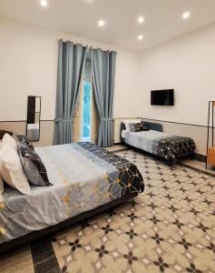 una camera da letto con due letti e una TV a schermo piatto di Hotel Meublè Santa Chiara Suite a Napoli