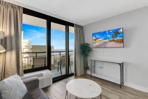 默特尔比奇Captivating Coastal Charm - Oceanview Suite! PG 504的带沙发和大窗户的客厅