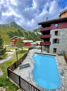 a large swimming pool in front of a building at ARC 1950, Appartement style Chalet Haut de Gamme 2 chambres, 6 personnes in Arc 1950