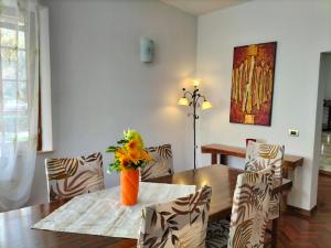 a dining room with a table with a vase of flowers on it at Casa vacanze Bonardini in Castiglione del Lago +10 photos