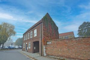 a brick building with ivy growing on the side of it at TudorRose Townhouse - A New Unique Town Centre Home in King's Lynn