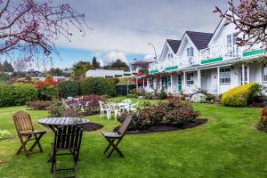 a patio with chairs and a table in a yard at Phoenix Thermal Resort - Taupo in Taupo