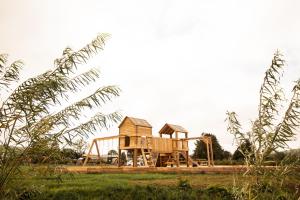 a wooden playground in a field with trees at Daffodil in Rhayader