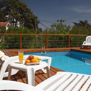 a table with a plate of fruit next to a swimming pool at Hosteria Nirvana in Villa Gesell