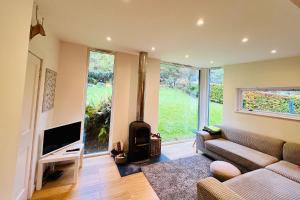un soggiorno con divano e camino di 4 Balvaig Cottage a Stirling
