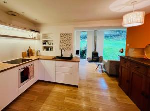 a kitchen with white cabinets and a large window at 4 Balvaig Cottage, Strathyre in Stirling