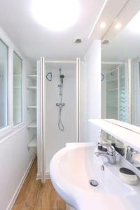 een witte badkamer met een wastafel en een douche bij L'Hortillon Amiens 4 pers 8min Centre ville & Gare in Amiens