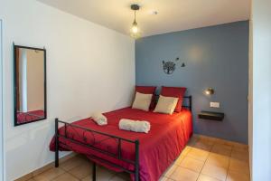 een slaapkamer met een rood bed en een spiegel bij L'Hortillon Amiens 4 pers 8min Centre ville & Gare in Amiens