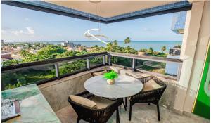 un tavolo e sedie su un balcone con vista sull'oceano di Blue Beach Resort Residence Cabedelo-João Pessoa PB AP 704-C a Cabedelo