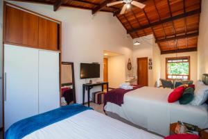 a hotel room with two beds and a tv at Villa Rica Pousada in Brumadinho +65 photos