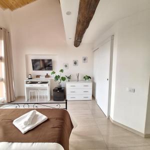 a white bedroom with a bed and a desk at San Vincenzo Rooms in Anzola dell'Emilia