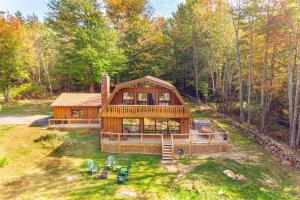 a large wooden house in the middle of the forest at ADK Whiteface Chalet with Hot Tub, Dog Friendly! in Wilmington