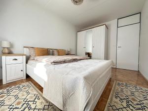 a white bedroom with a large bed and a mirror at Sarajevo center in Sarajevo