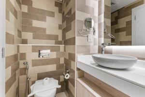 ein Badezimmer mit Waschbecken und Toilette in der Unterkunft Seven Palm Hotel with West beach access in Dubai + 10 Fotos