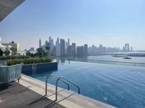 einen Pool mit einer Skyline der Stadt im Hintergrund in der Unterkunft Seven Palm Hotel with West beach access in Dubai